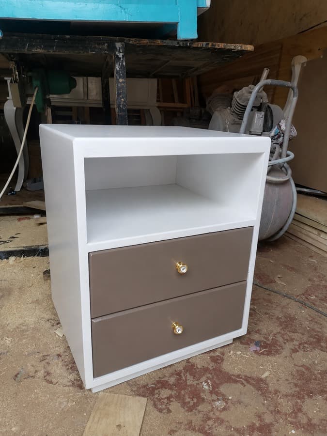 A second bedside table, unfinished, standing in a workshop